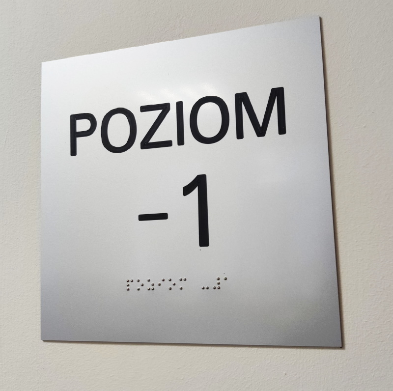 Zdjęcie tabliczki w brajlu z napisem poziom -1